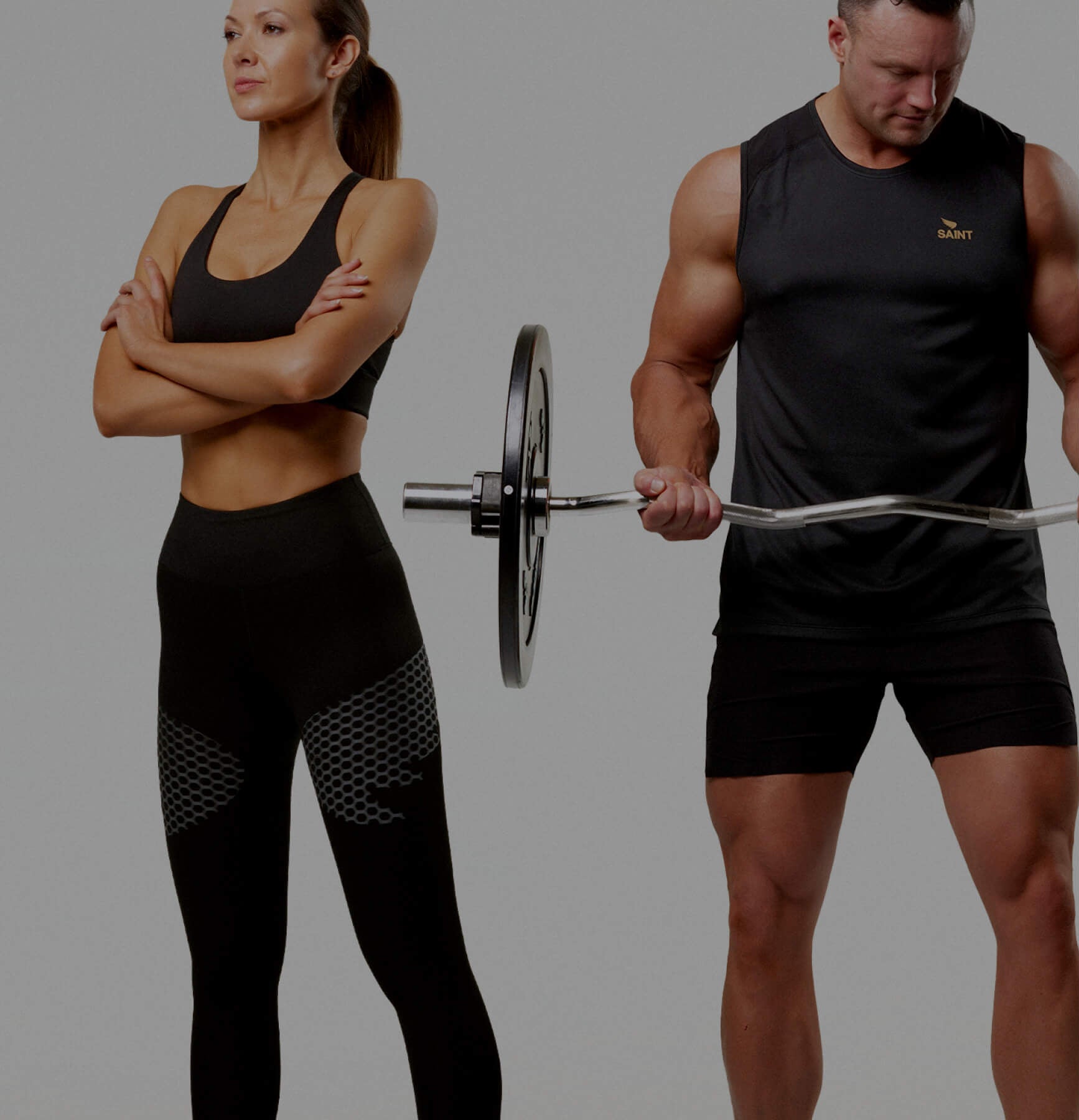 Two people in athletic wear standing with a barbell on a gray background